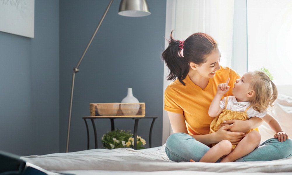 Mamička s dieťaťom sa tešia vo svojej príjemnej modrej spálni.
